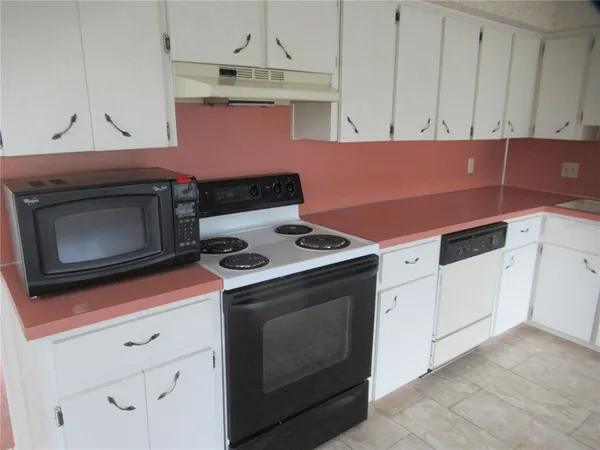 a kitchen with cabinets and white appliances