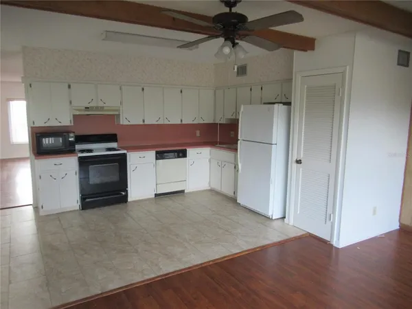 a kitchen with stainless steel appliances a stove a microwave and white cabinets