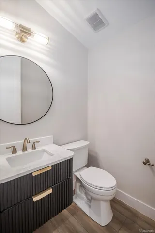 a bathroom with a sink vanity mirror and toilet
