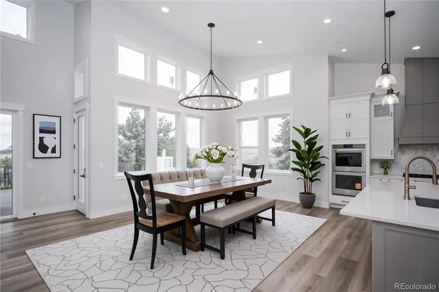 a dining room filled chandelier and wooden floor