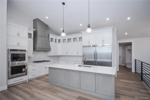 an open kitchen with a sink and refrigerator