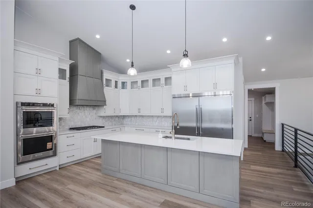 an open kitchen with a sink and refrigerator