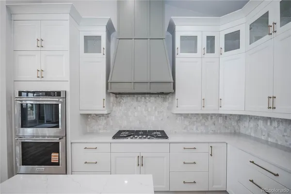 a kitchen with granite countertop white cabinets and stainless steel appliances