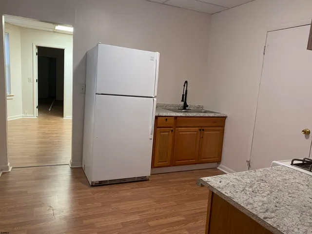 a kitchen with granite countertop a refrigerator and a sink