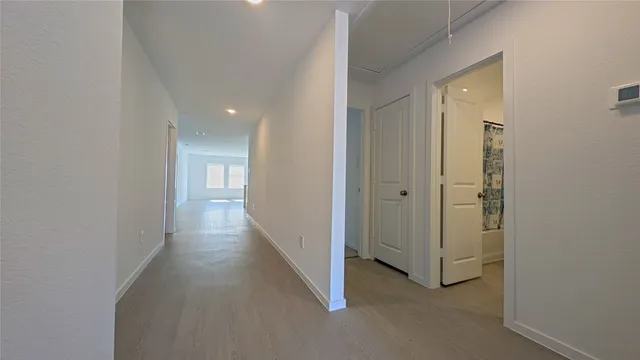 a view of a hallway with wooden floor