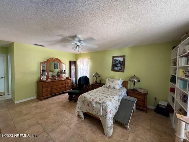 8 North Trident Place St. Augustine, FL 32080 - Photo 17 of 26 a spacious bedroom with a bed a couch and dresser