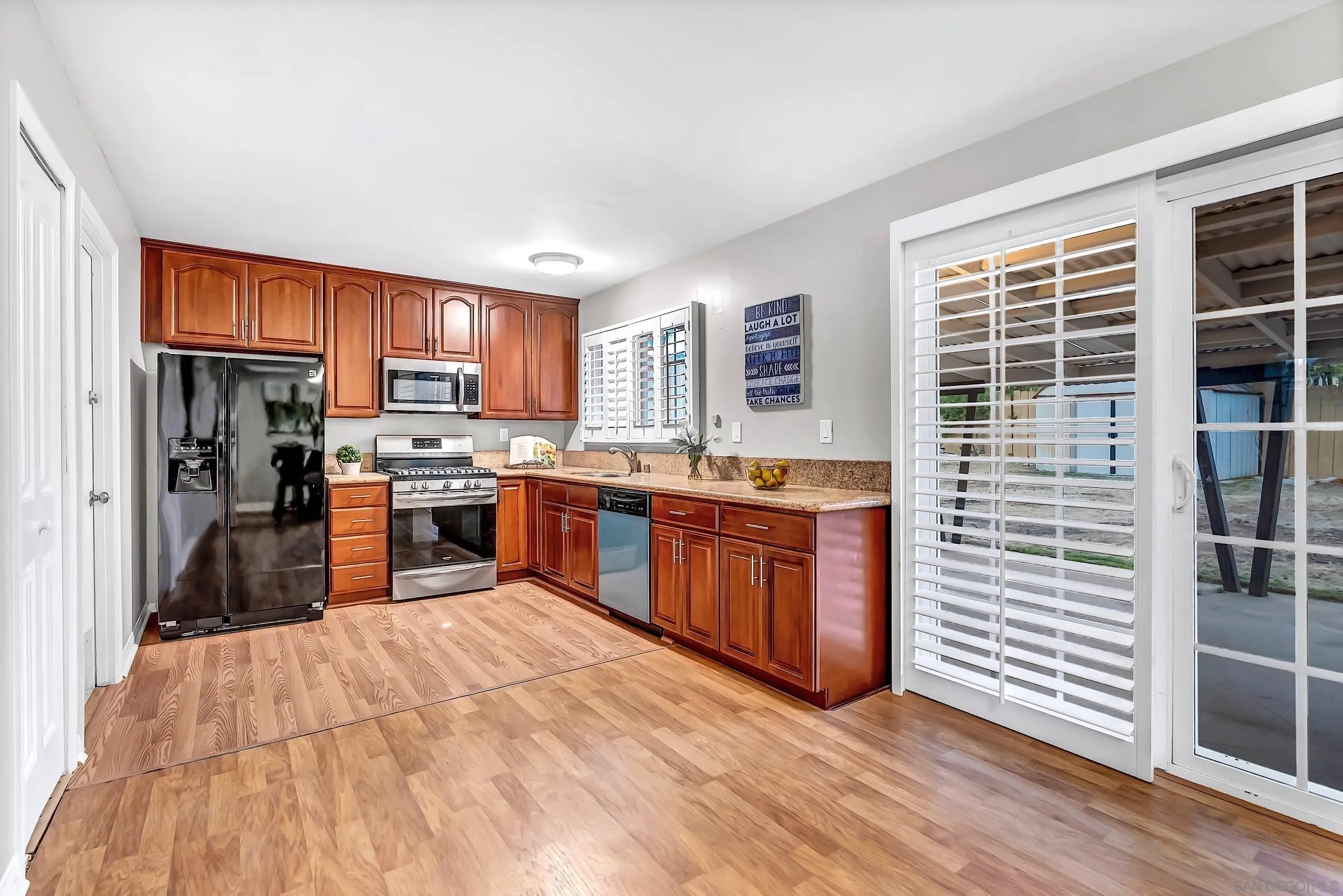9215 Lake Canyon Road Santee, CA 92071 - Photo 7 of 18 a kitchen with stainless steel appliances kitchen island granite countertop a stove a sink a refrigerator and cabinets