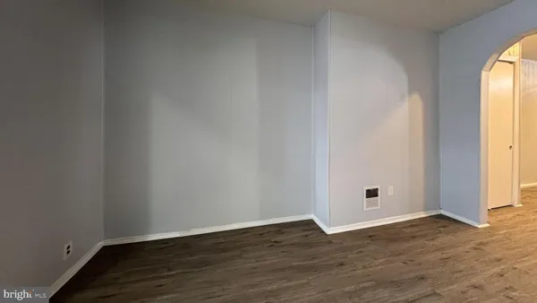 an empty room with wooden floor and window