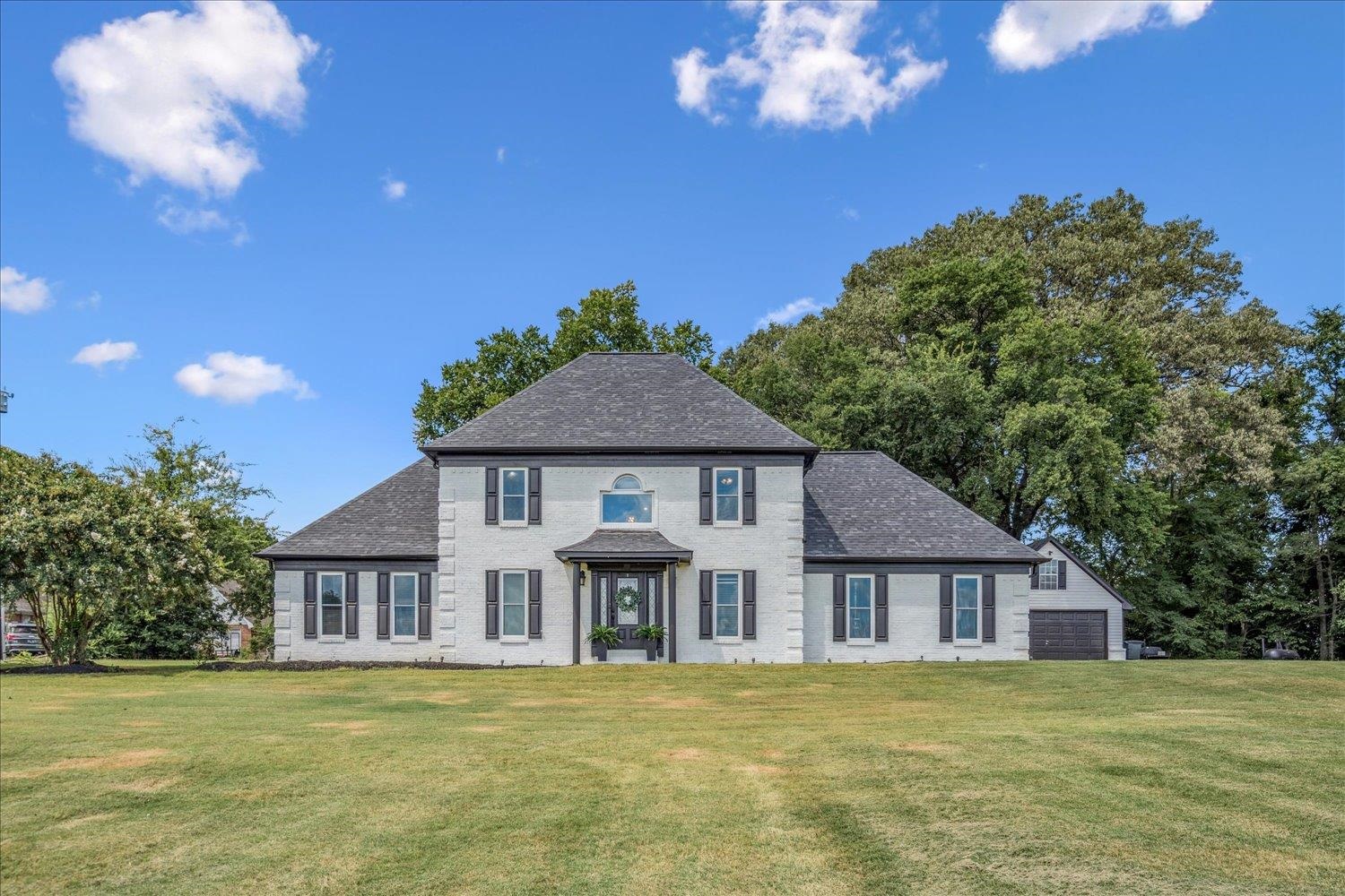 220 Sawmill Road Brighton, TN 38011 - Photo 1 of 25 View of front facade featuring a garage, a front lawn, roof with shingles, and brick siding
