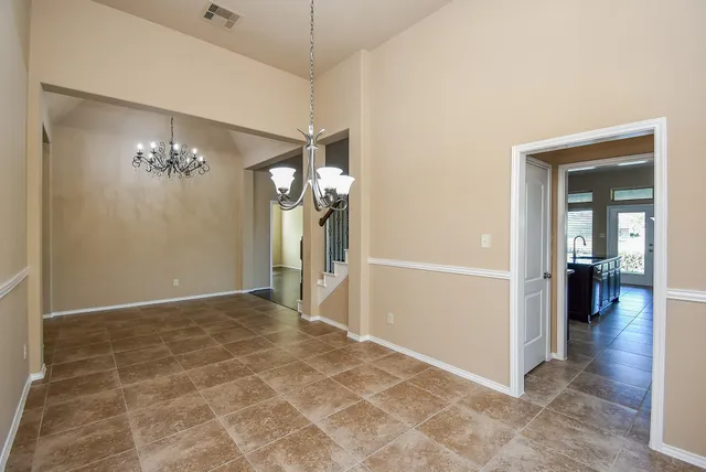 a view of a hallway with a chandelier fan and livingroom view