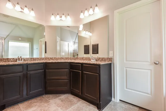 a bathroom with a granite countertop sink and a mirror