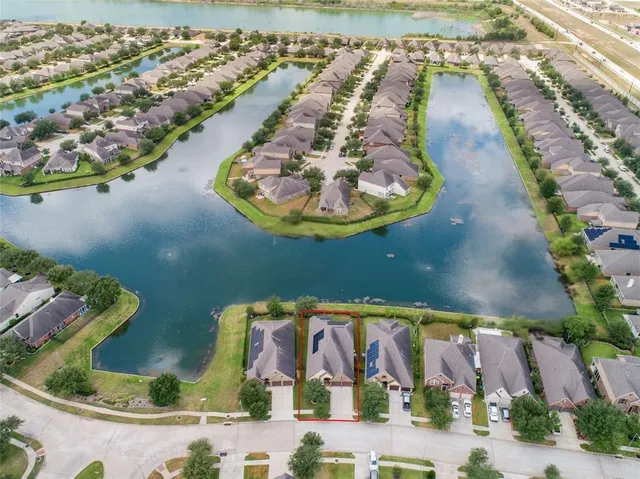 an aerial view of a house with a yard and lake view