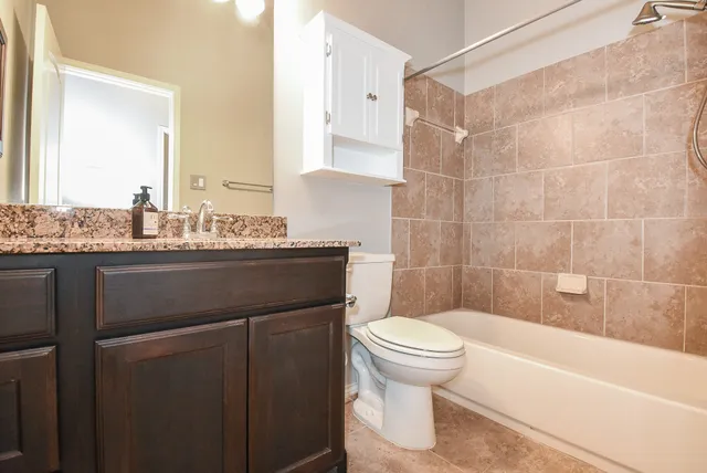 a bathroom with a sink toilet vanity and shower