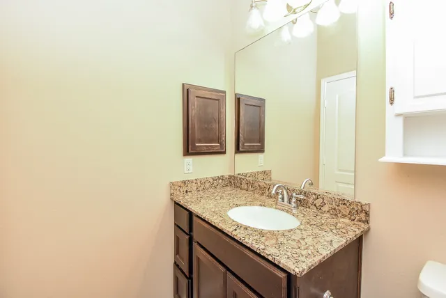 a bathroom with a granite countertop sink and a mirror