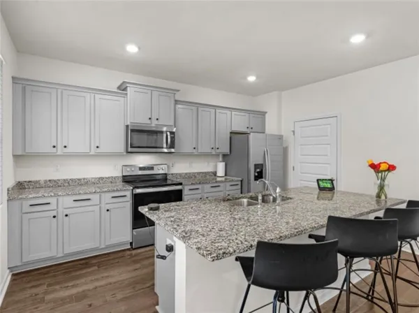 a kitchen with kitchen island granite countertop a table and chairs in it