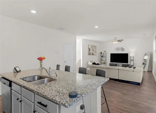a kitchen with granite countertop a sink and a stove top oven