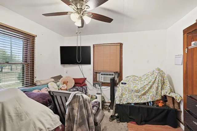 a bedroom with bed and a flat tv screen on the dresser