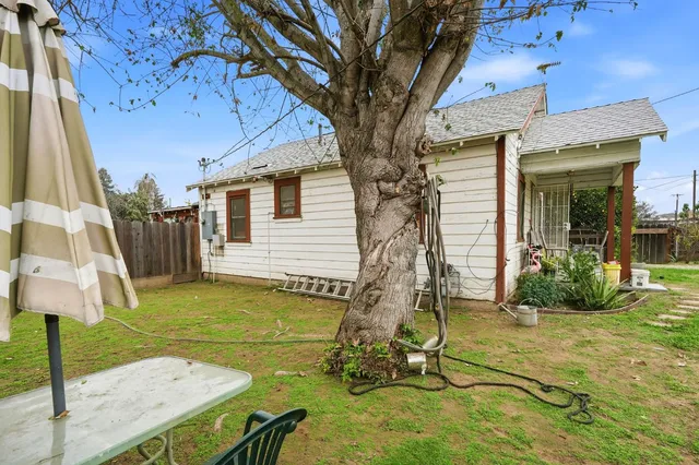 a backyard of a house with table and chairs