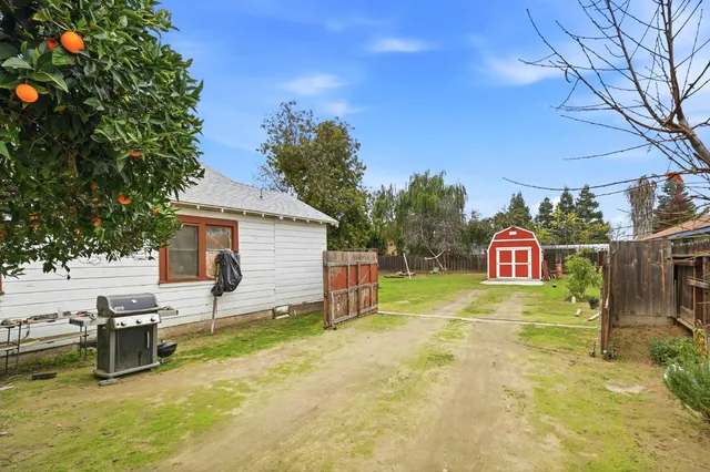 a view of a tiny house with backyard and garden