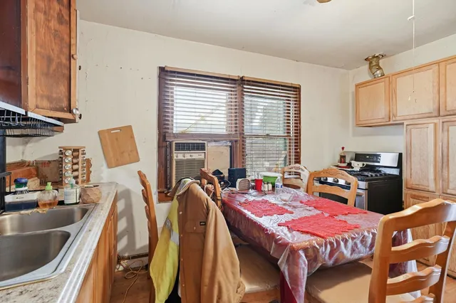 a bedroom with a bed next to a window with kitchen view