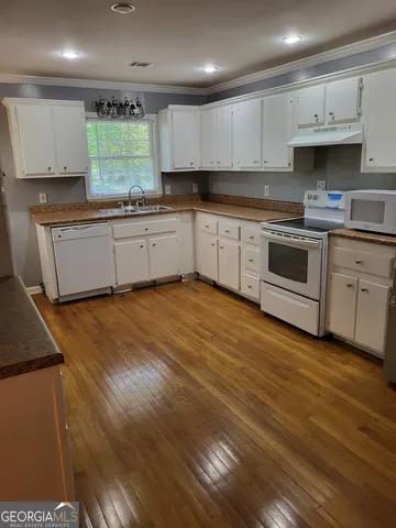 a kitchen with stainless steel appliances granite countertop a stove a sink and a microwave