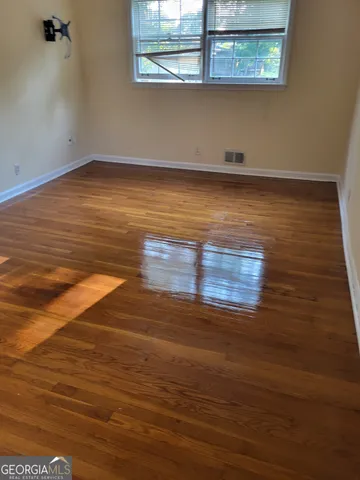 a view of a room with wooden floor and window