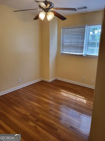 a view of a room with wooden floor and fan