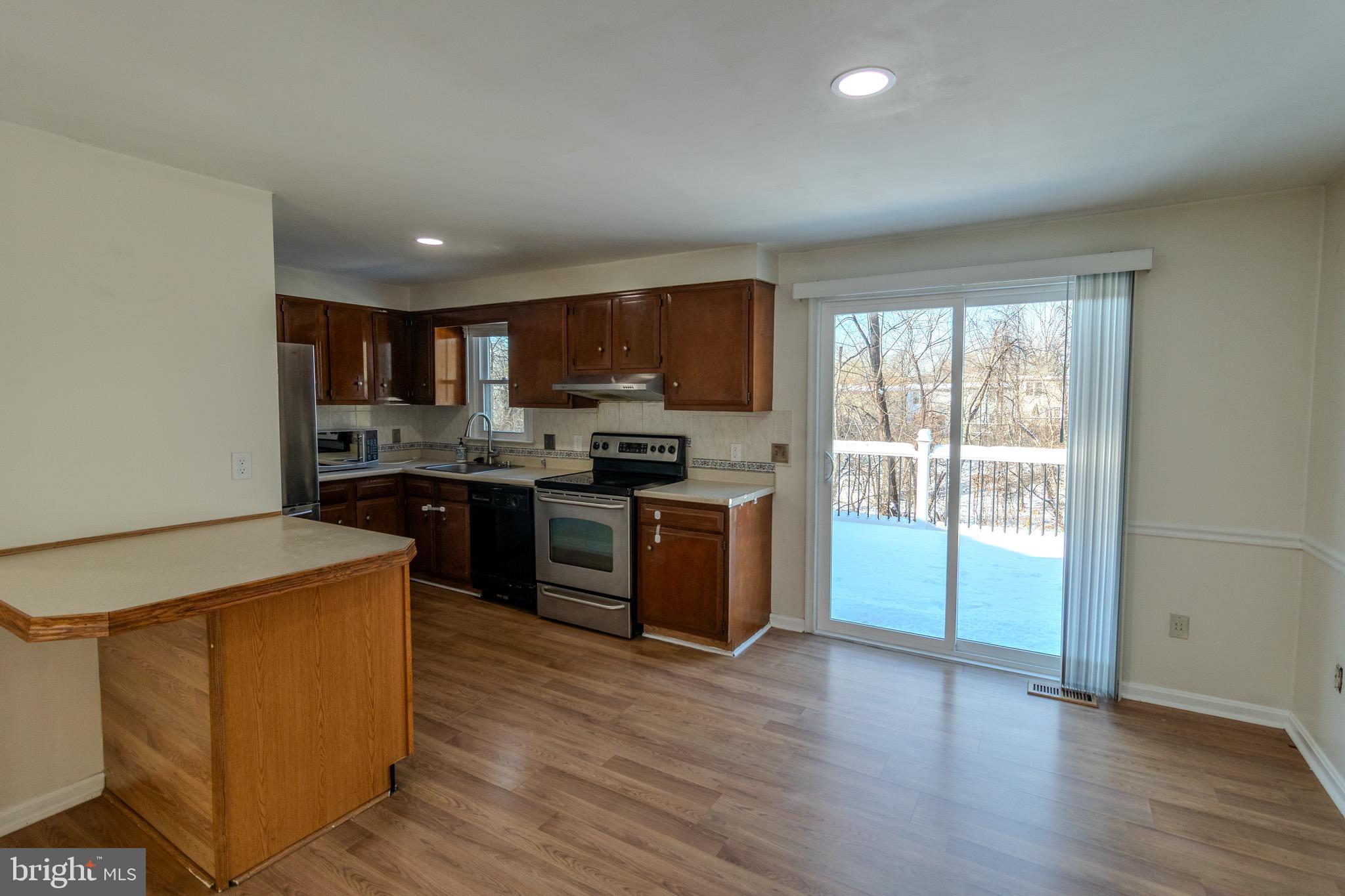 608 St Georges Station Road Reisterstown, MD 21136 - Photo 9 of 30 a kitchen with stainless steel appliances granite countertop a stove a sink dishwasher a refrigerator and a microwave oven with wooden floor