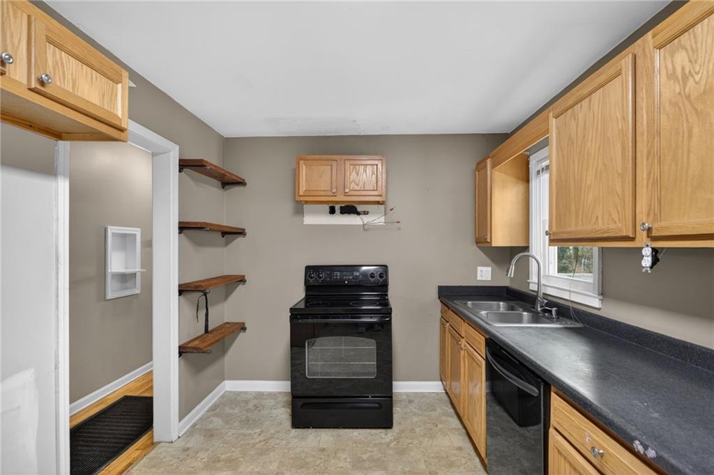 113 Maple Street Bremen, GA 30110 - Photo 7 of 23 a kitchen with a refrigerator and a stove top oven