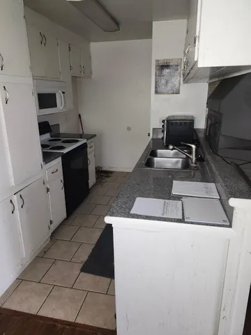 a kitchen with cabinets appliances and a sink
