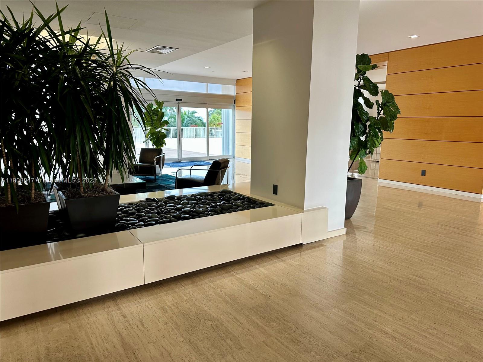 881 Ocean Drive, Unit 22E Key Biscayne, FL 33149 - Photo 16 of 16 a living room with a couch and a potted plant