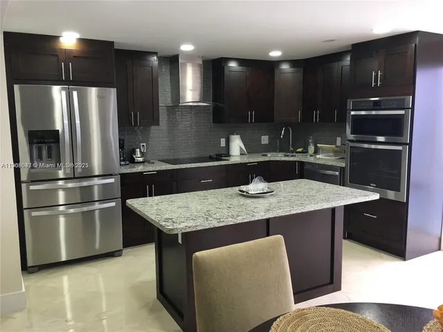 a kitchen with stainless steel appliances granite countertop a refrigerator and a sink