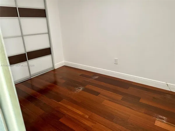 a view of an empty room with wooden floor