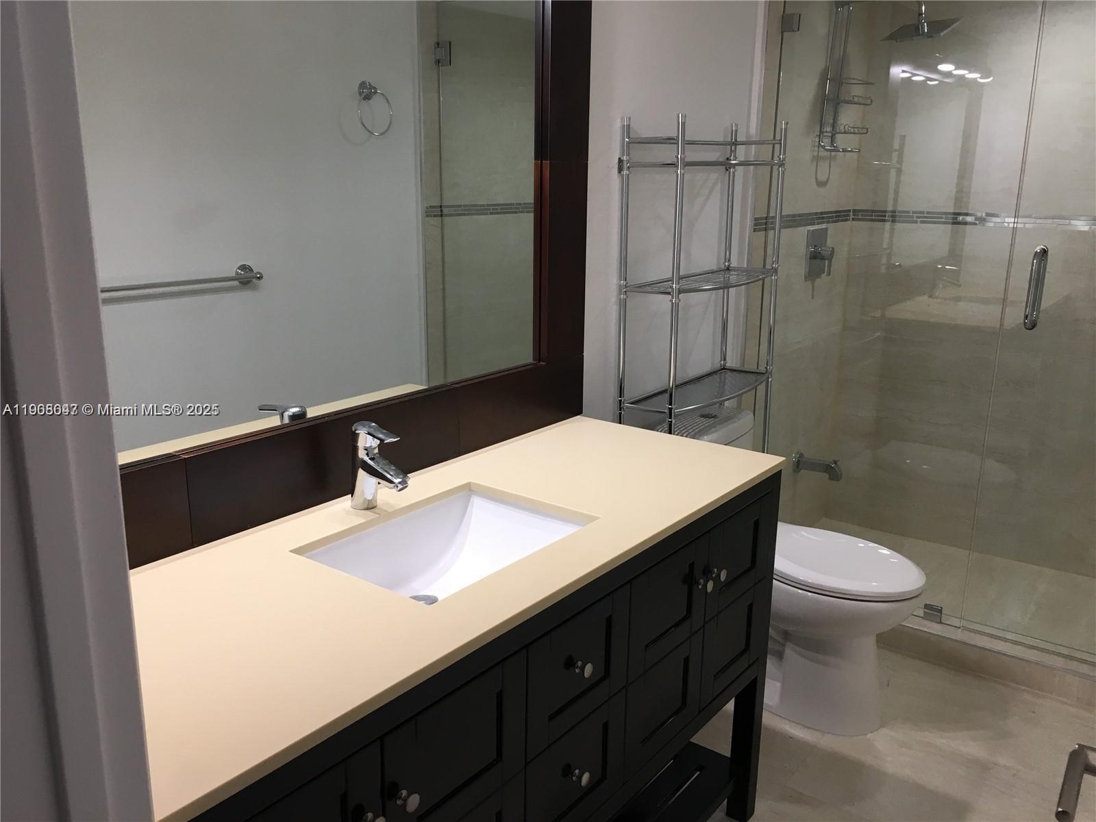 881 Ocean Drive, Unit 22E Key Biscayne, FL 33149 - Photo 10 of 16 a bathroom with a sink a toilet and shower