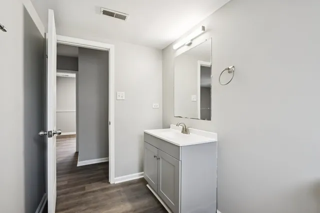 a spacious bathroom with a double vanity sink a mirror and a