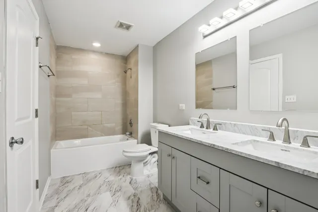 a bathroom with a double vanity sink mirror and