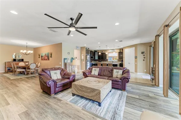 a kitchen with stainless steel appliances granite countertop a refrigerator a oven a sink a dining table and chairs