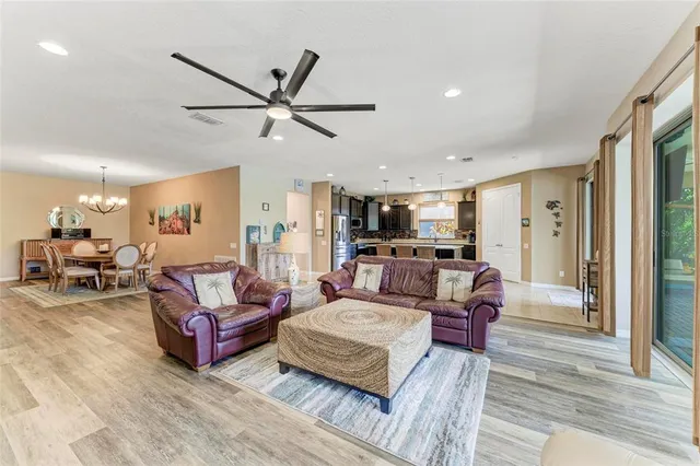 a kitchen with stainless steel appliances granite countertop a refrigerator a oven a sink a dining table and chairs