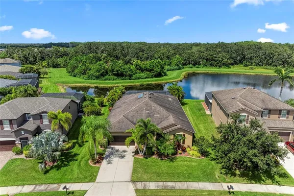 an aerial view of a house with a garden and lake view