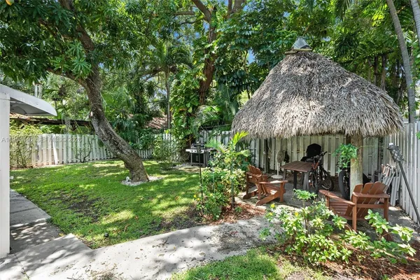 a backyard of a house with a table and chairs under an umbrella
