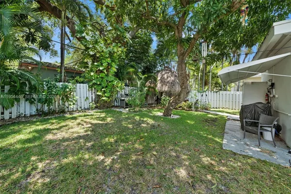 a view of backyard with table and chairs and potted plants