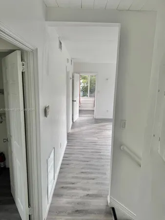 a view of a hallway with wooden floor and closet