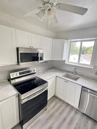 a kitchen with granite countertop a stove and a microwave