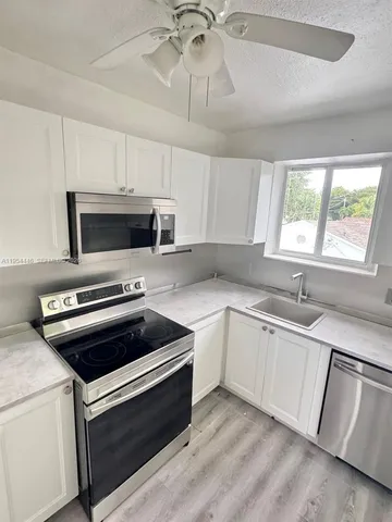 a kitchen with granite countertop a stove and a microwave