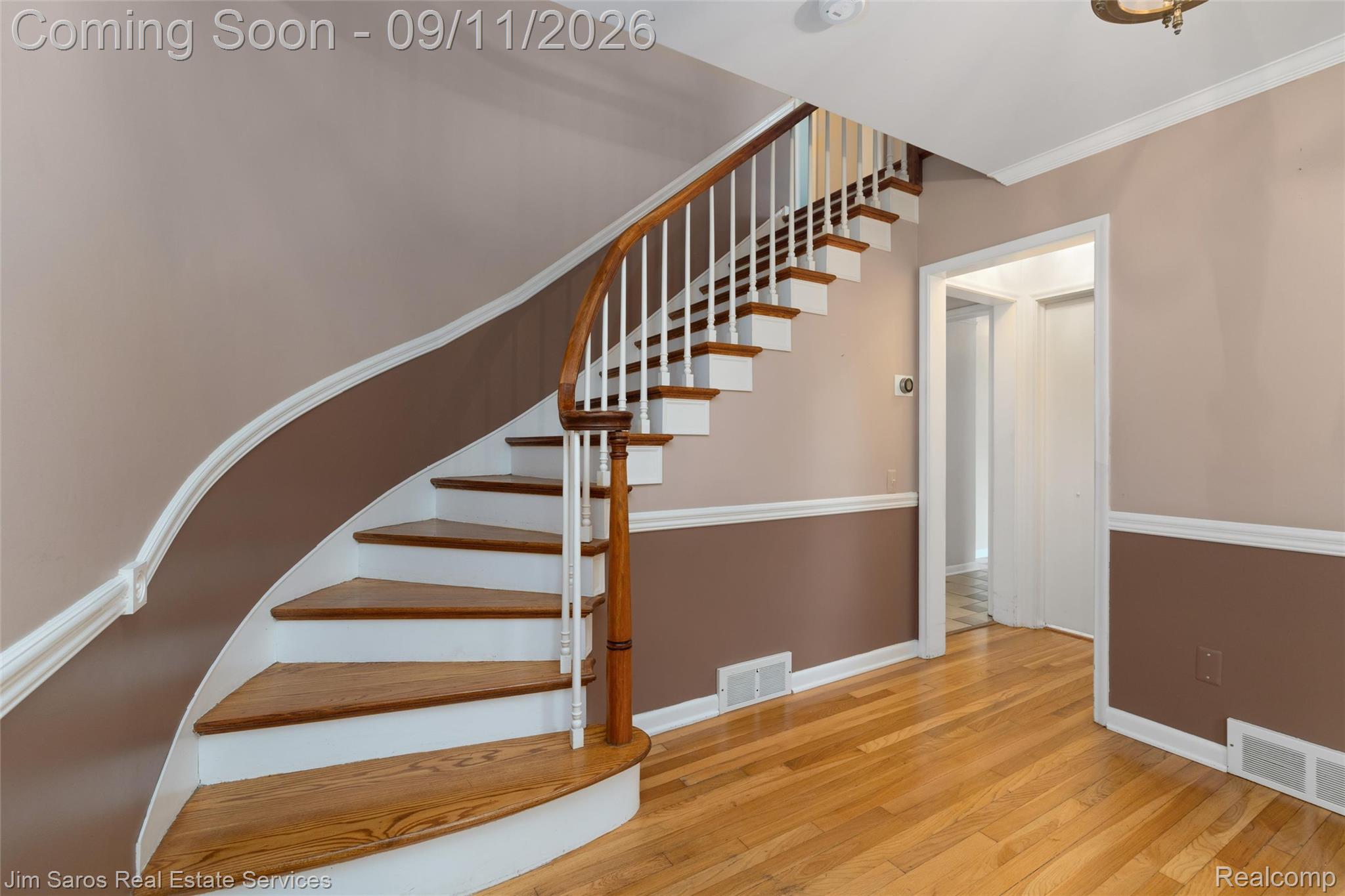 1445 Devonshire Road Grosse Pointe, MI 48230 - Photo 9 of 30 Curved staircase with wood treads and white risers, complemented by wood-finish flooring