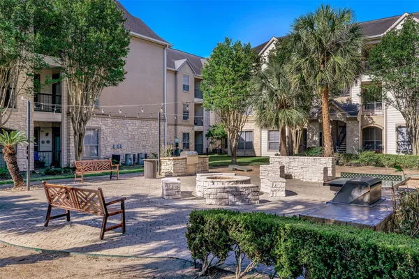 a view of a patio with table and chairs potted plants and large tree
