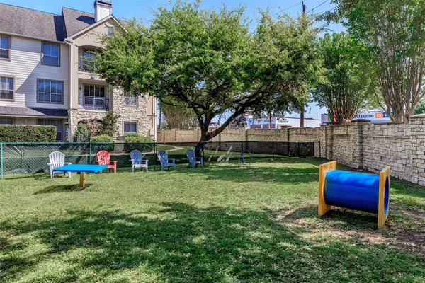 a view of backyard with table and chairs and potted plants and large trees