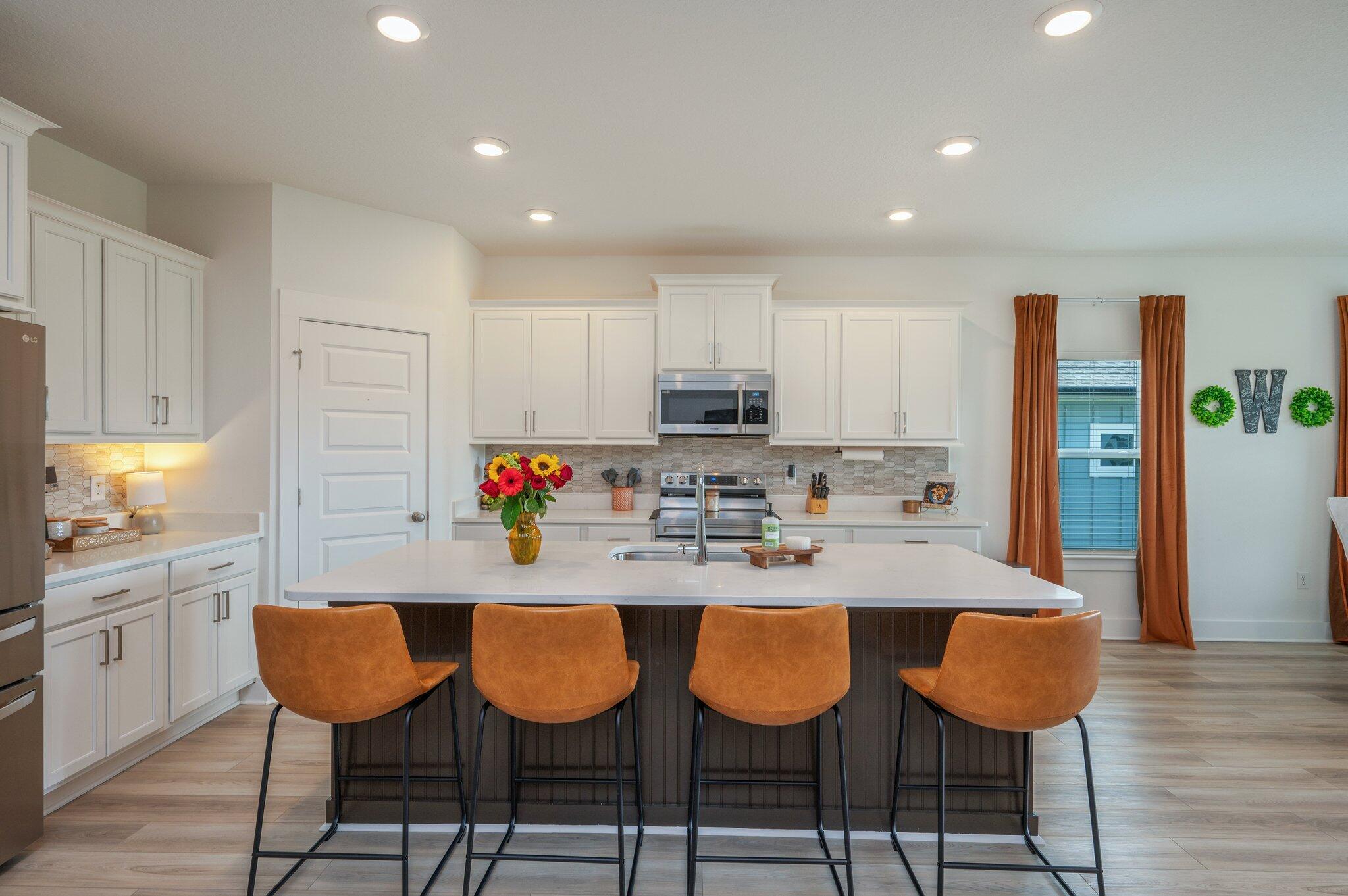 134 Blooming Cove Crestview, FL 32539 - Photo 11 of 50 a kitchen with stainless steel appliances granite countertop a dining table chairs and white cabinets