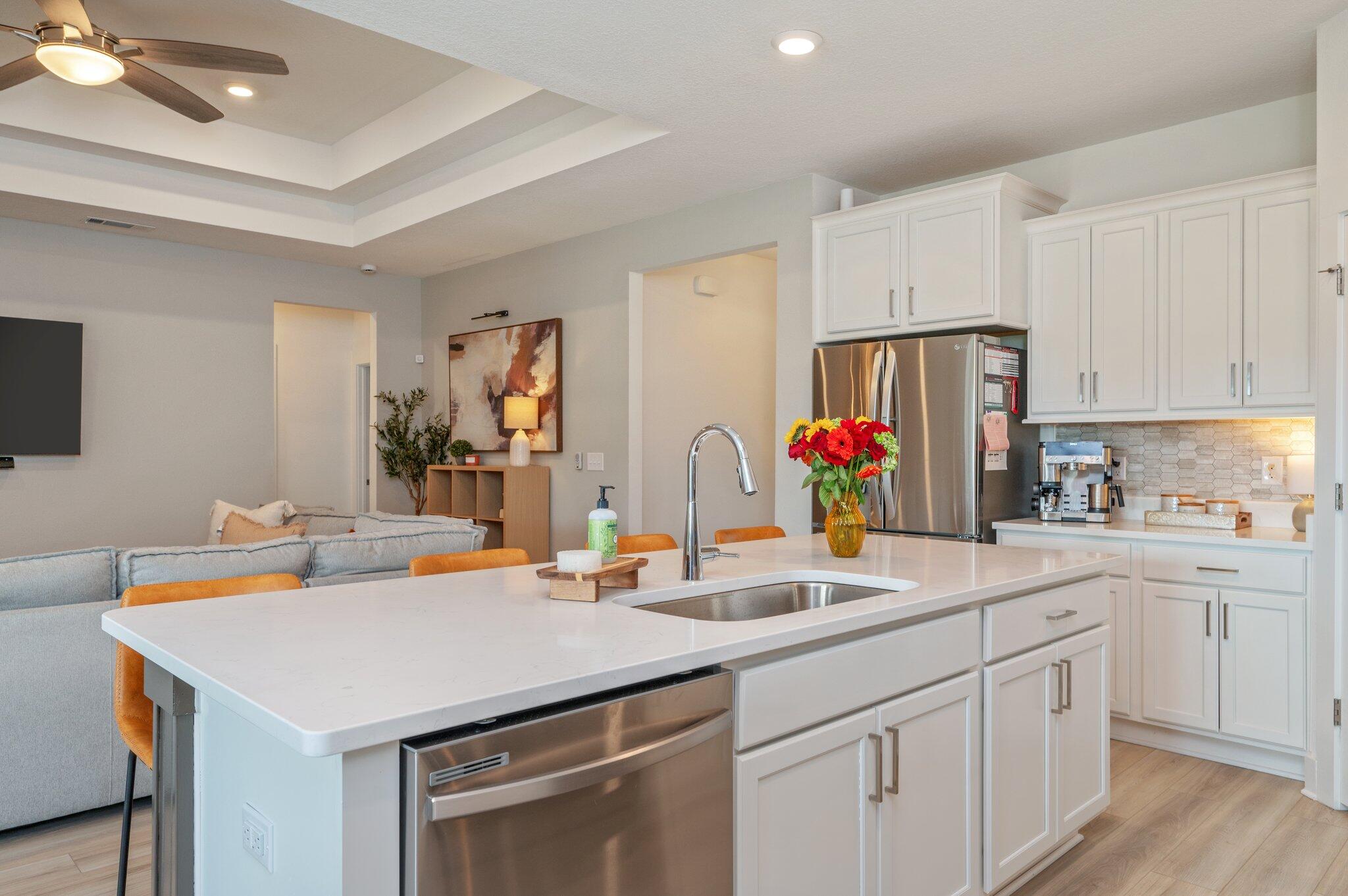 134 Blooming Cove Crestview, FL 32539 - Photo 13 of 50 a kitchen with stainless steel appliances a sink a stove and white cabinets