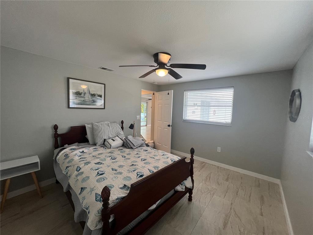 129 Northshore Terrace Punta Gorda, FL 33980 - Photo 11 of 37 a bedroom with a bed and a chandelier